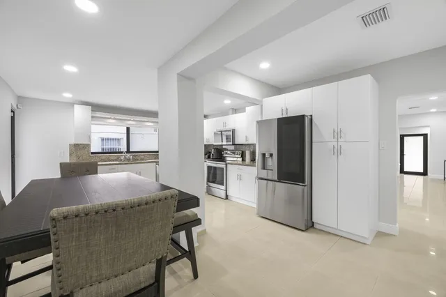 a kitchen with refrigerator and kitchen island