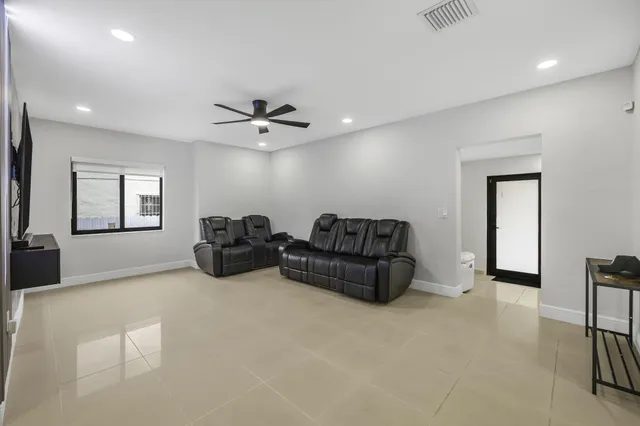 a living room with furniture and a ceiling fan