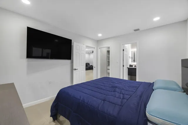 a large bedroom with a bed and a flat screen tv