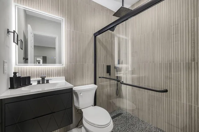 a bathroom with a sink a toilet and shower