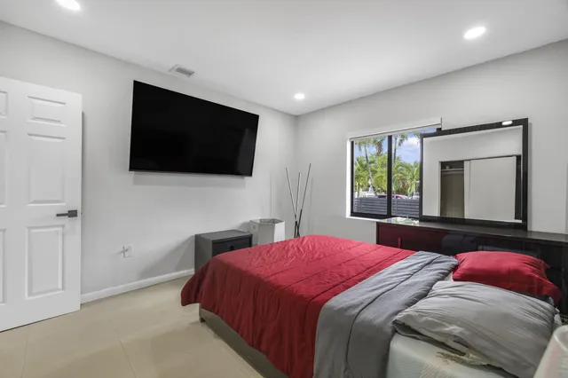 a bedroom with a large bed and a flat screen tv