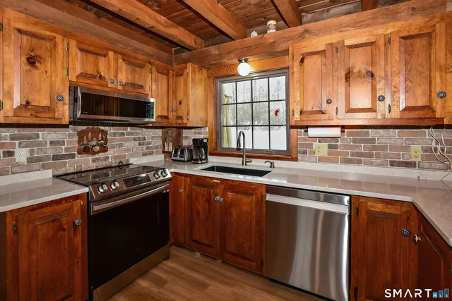 a kitchen with stainless steel appliances a stove sink microwave and cabinets