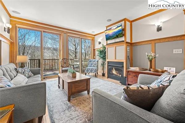 a living room with fireplace furniture and a large window