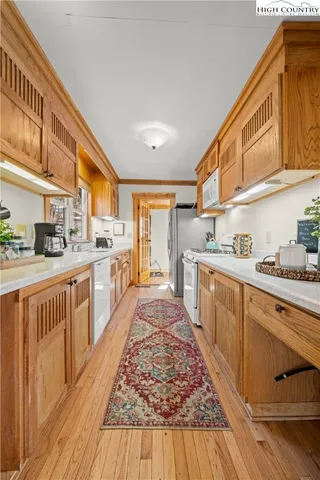 a kitchen with cabinets wooden floor and stainless steel appliances