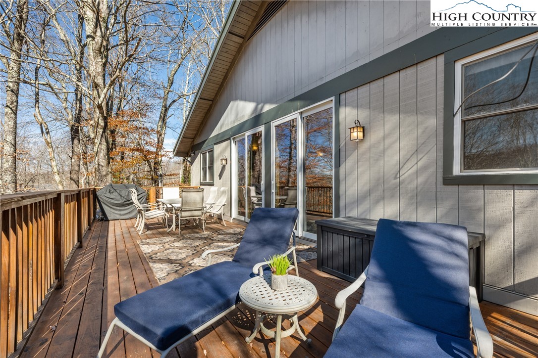 169 Hornbeam Road Beech Mountain, NC 28604 - Photo 27 of 48 a outdoor dining space with furniture wooden floor and a fireplace