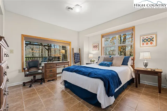 a large bedroom with a bed and large window