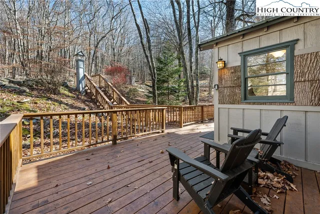 a view of a roof deck with wooden chairs and wooden fence