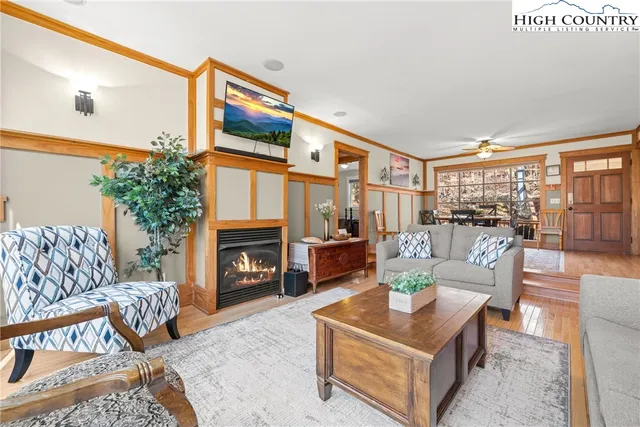 a living room with furniture a fireplace and a large window