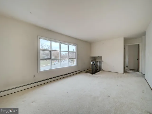 an empty room with furniture and large window
