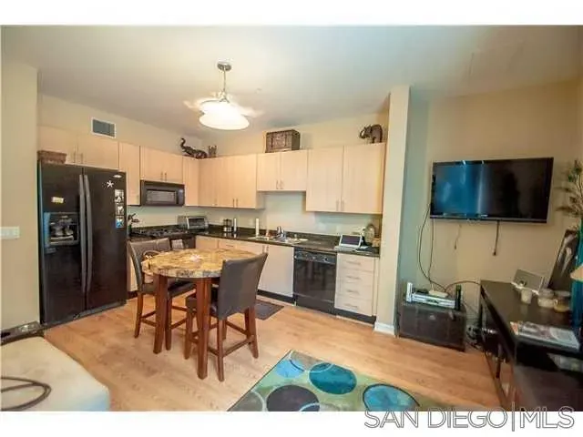 a kitchen with a dining table chairs stainless steel appliances and cabinets