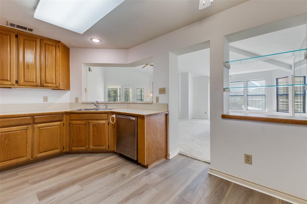 9939 Waterfront Trail Rowlett, TX 75087 - Photo 12 of 25 a kitchen with granite countertop wooden floors and white cabinets