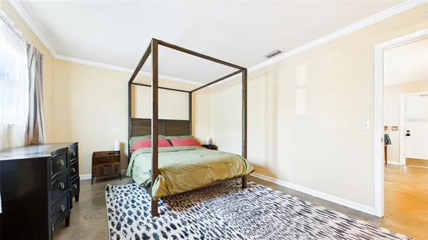 a bedroom with a bed and wooden floor