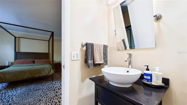 a en suite bathroom with a granite countertop sink and a mirror