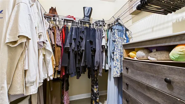 a view of walk in closet with clothes