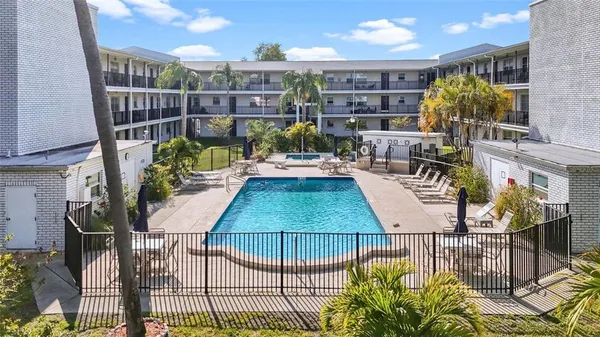 a view of a swimming pool with outdoor seating and plants
