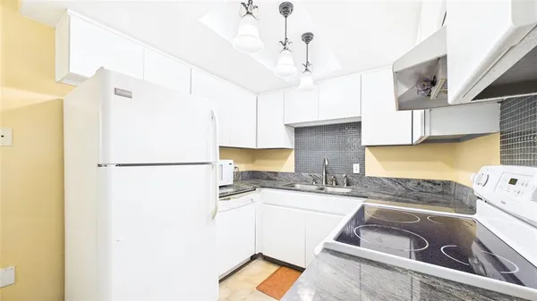 a kitchen with stainless steel appliances granite countertop a sink a refrigerator a stove a washer and dryer