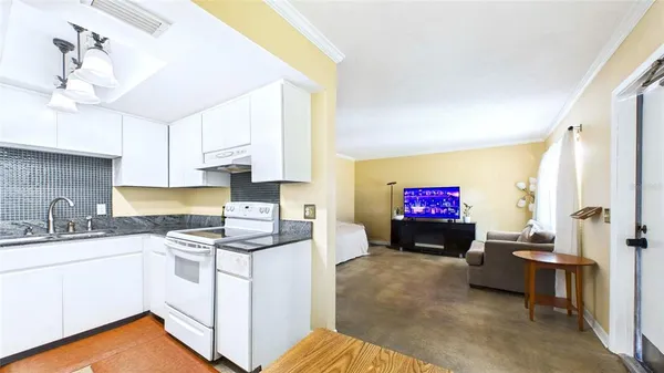 a kitchen with stainless steel appliances a sink cabinets and wooden floor