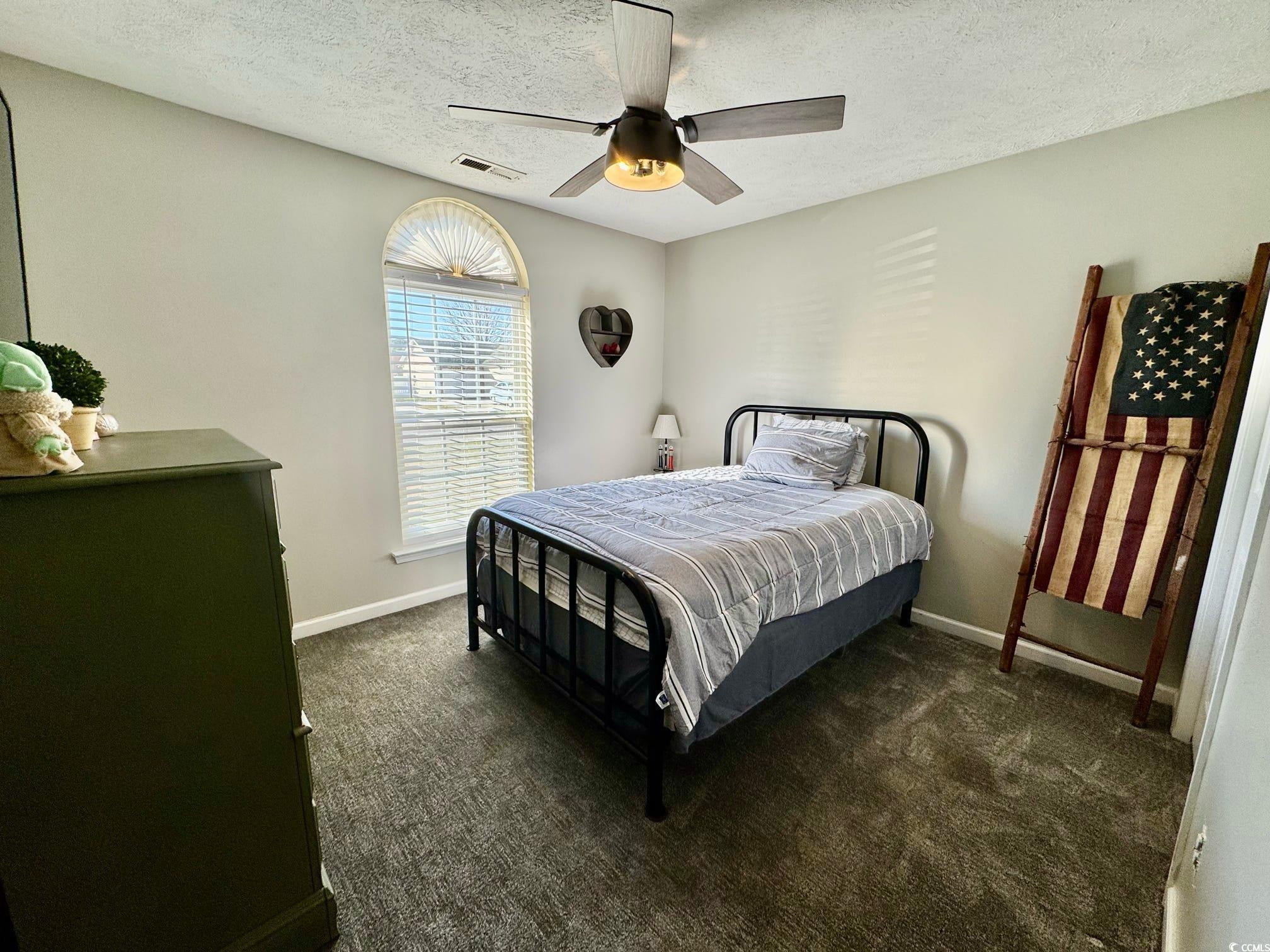 9883 Conifer Lane Murrells Inlet, SC 29576 - Photo 13 of 24 Bedroom with baseboards, visible vents, dark carpe