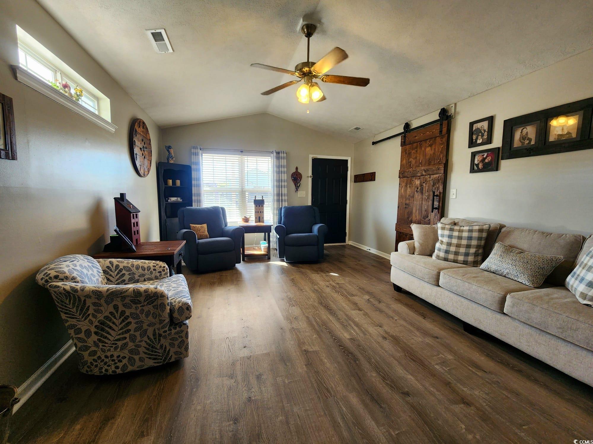 9883 Conifer Lane Murrells Inlet, SC 29576 - Photo 3 of 24 Living room with visible vents, a ceiling fan, woo