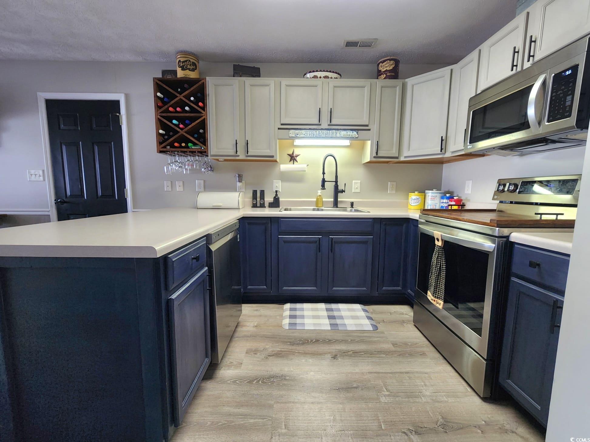 9883 Conifer Lane Murrells Inlet, SC 29576 - Photo 6 of 24 Kitchen with visible vents, light wood finished fl