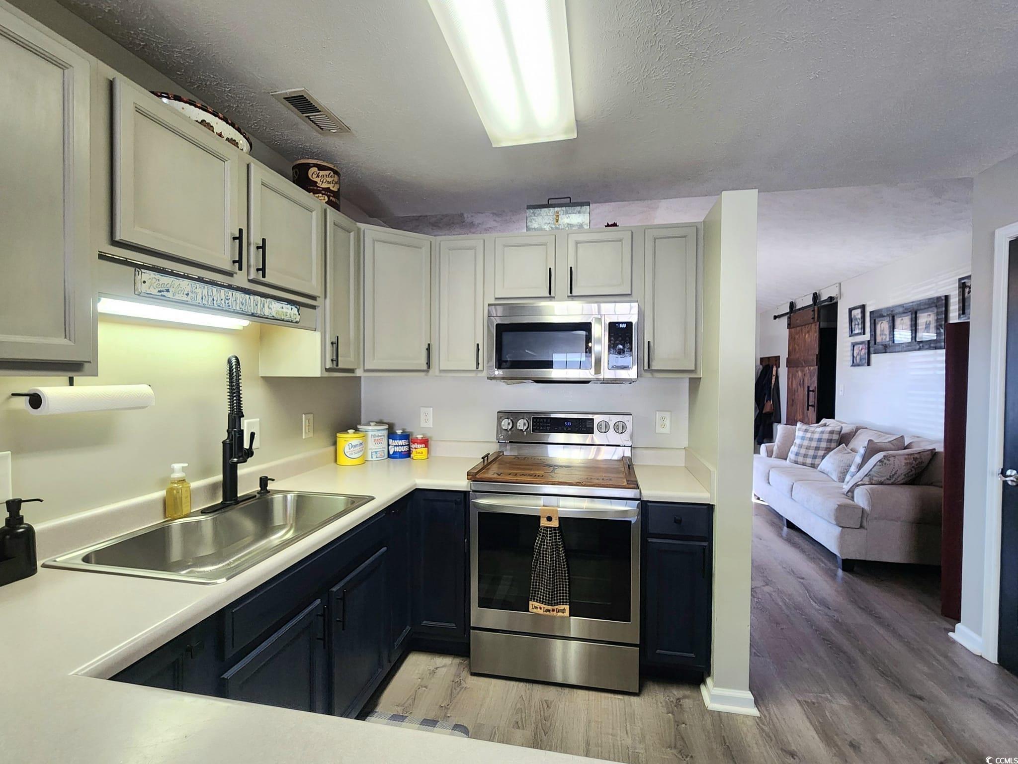 9883 Conifer Lane Murrells Inlet, SC 29576 - Photo 7 of 24 Kitchen with visible vents, a sink, a barn door, a