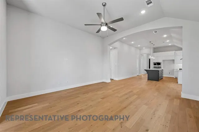 a view of an empty room and kitchen view