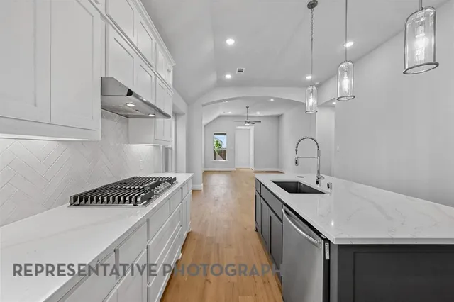 a kitchen with a sink a stove and cabinets