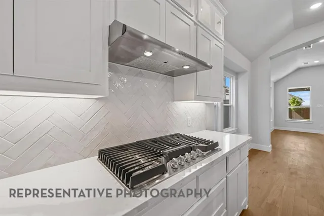 a kitchen with a stove and a wooden floor