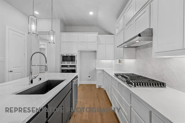 a kitchen with stainless steel appliances a sink a stove and a refrigerator