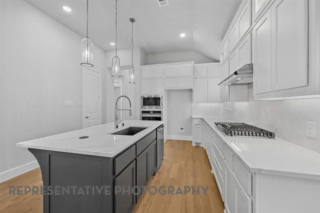 a kitchen with a sink stove and cabinets