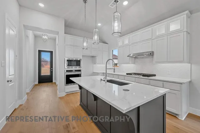 a kitchen that has a sink a stove and a refrigerator