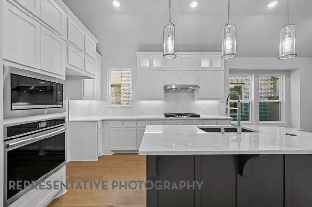 a kitchen with stainless steel appliances a sink a stove and cabinets