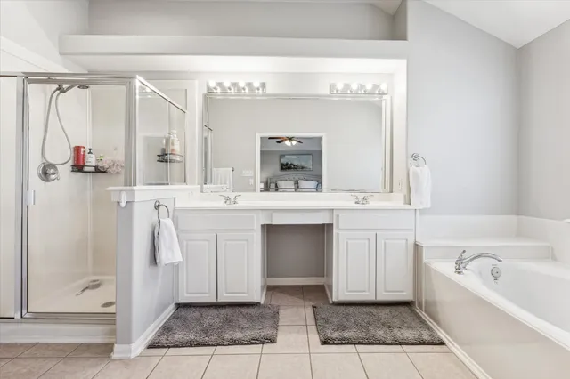 a bathroom with a double vanity sink mirror and bathtub