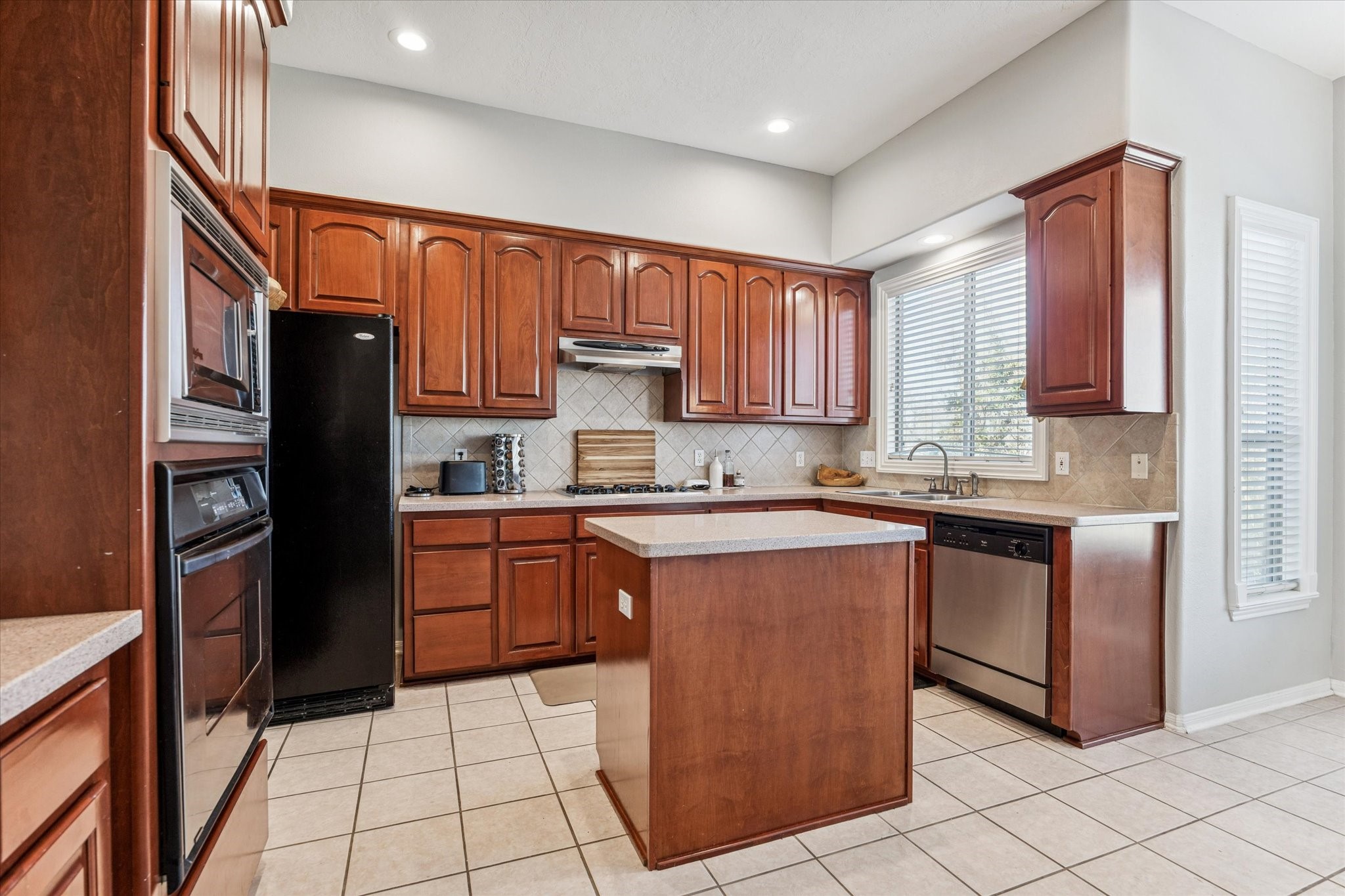 1802 Stacy Falls Houston, TX 77008 - Photo 7 of 21 Spacious kitchen with silestone counters, abundant storage, refrigerator stays. Window views green space behind property. Convenient island.