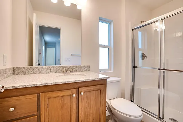 a bathroom with a granite countertop sink toilet and shower
