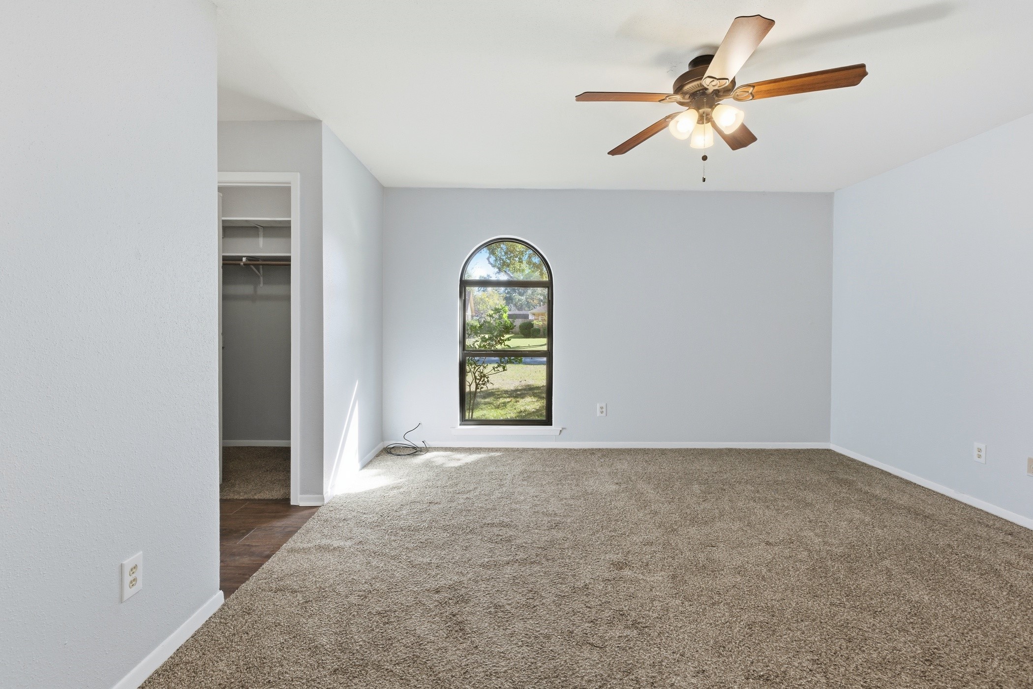 3721 Avenue R Rosenberg, TX 77471 - Photo 25 of 43 Spacious primary bedroom with large arched window offering natural light and front-yard views.