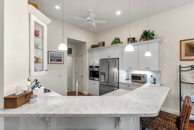a kitchen with stainless steel appliances granite countertop a sink refrigerator and cabinets