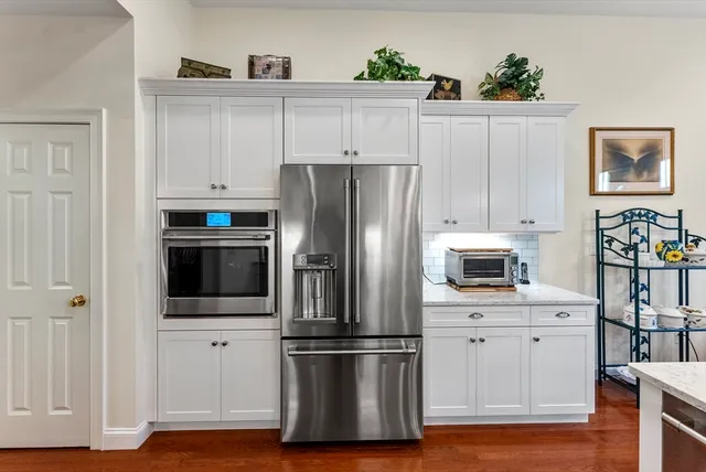 a kitchen with cabinets stainless steel appliances and wooden floor