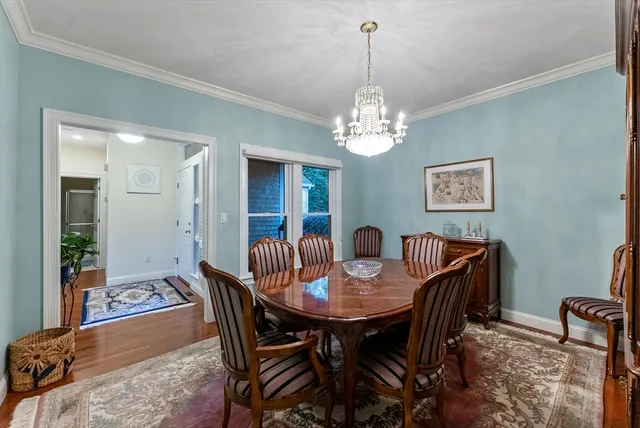 a view of a dining room with furniture a chandelier and wooden floor
