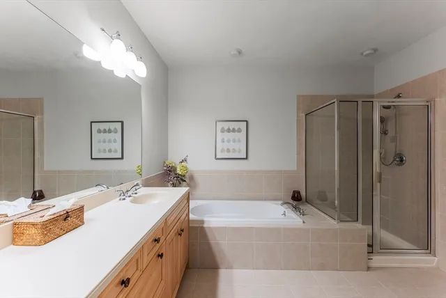 a spacious bathroom with a tub a double vanity sink and mirror