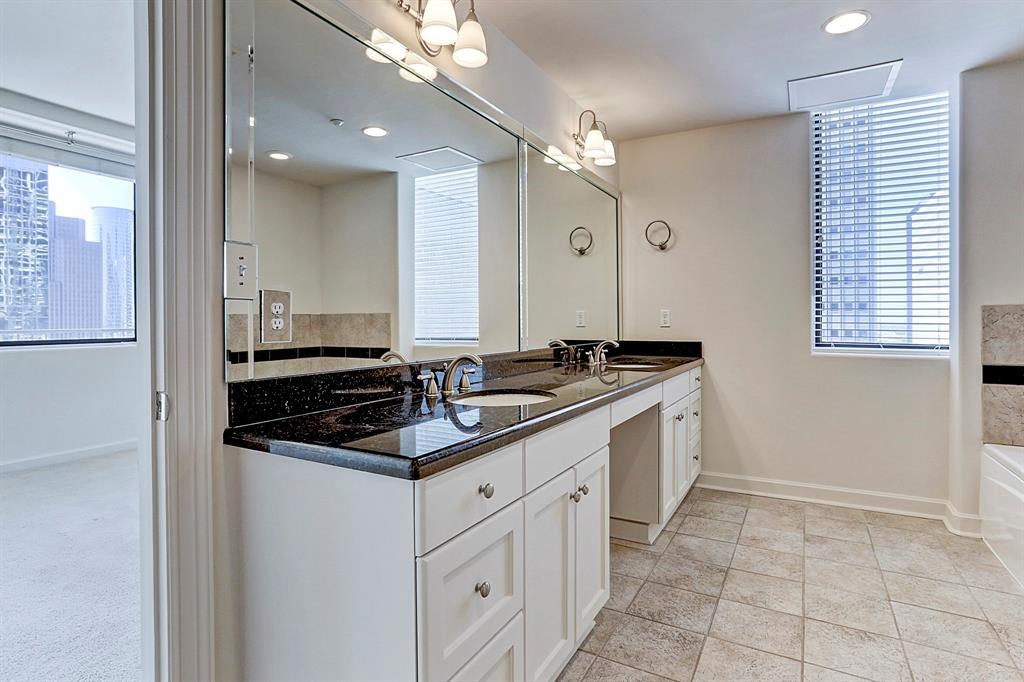 914 Main Street, Unit 1806 Houston, TX 77002 - Photo 5 of 21 a kitchen with granite countertop a sink and cabinets