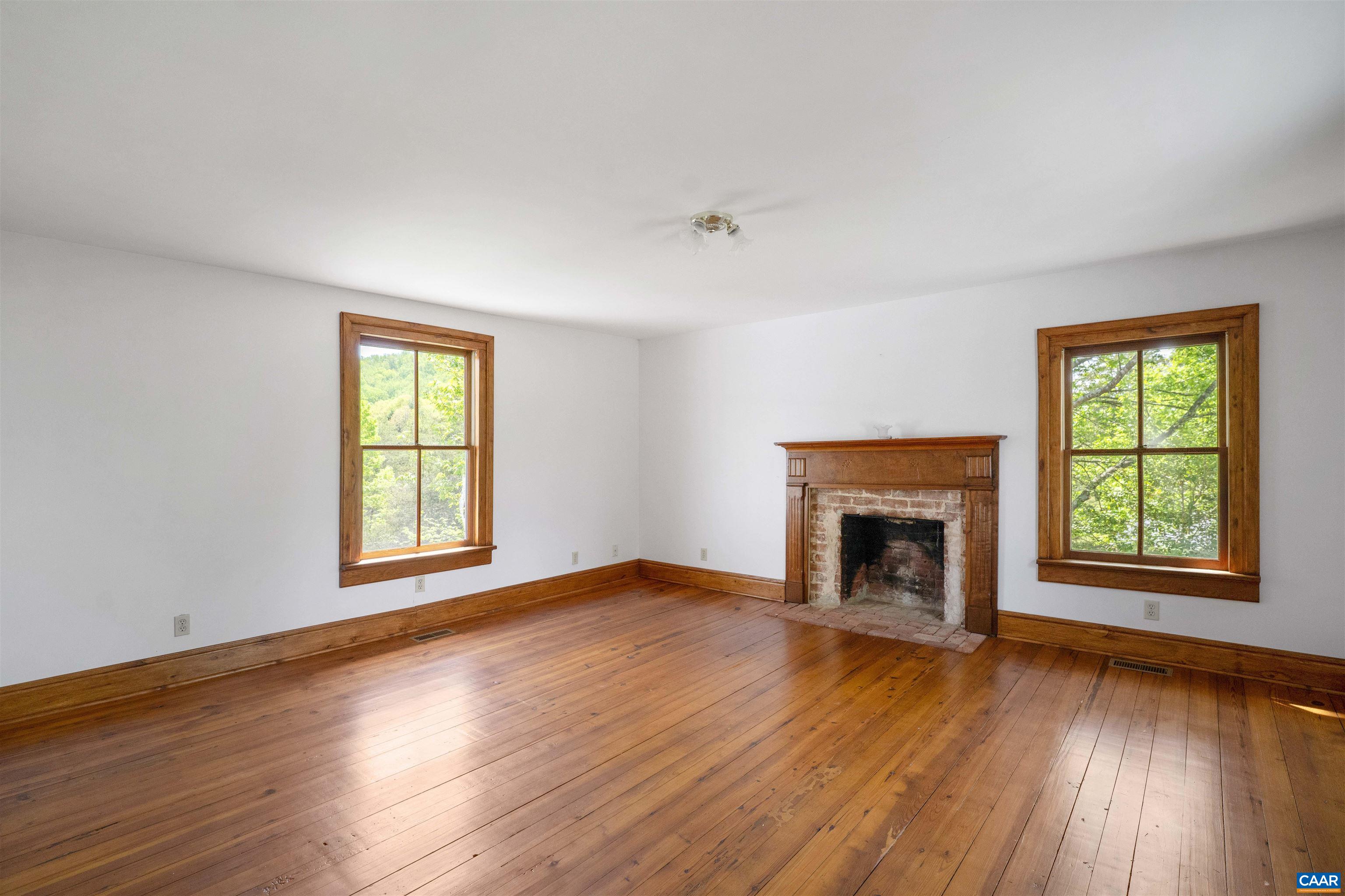 1888 Craigs Store Road Afton, VA 22920 - Photo 26 of 73 an empty room with windows a fireplace and wooden floor