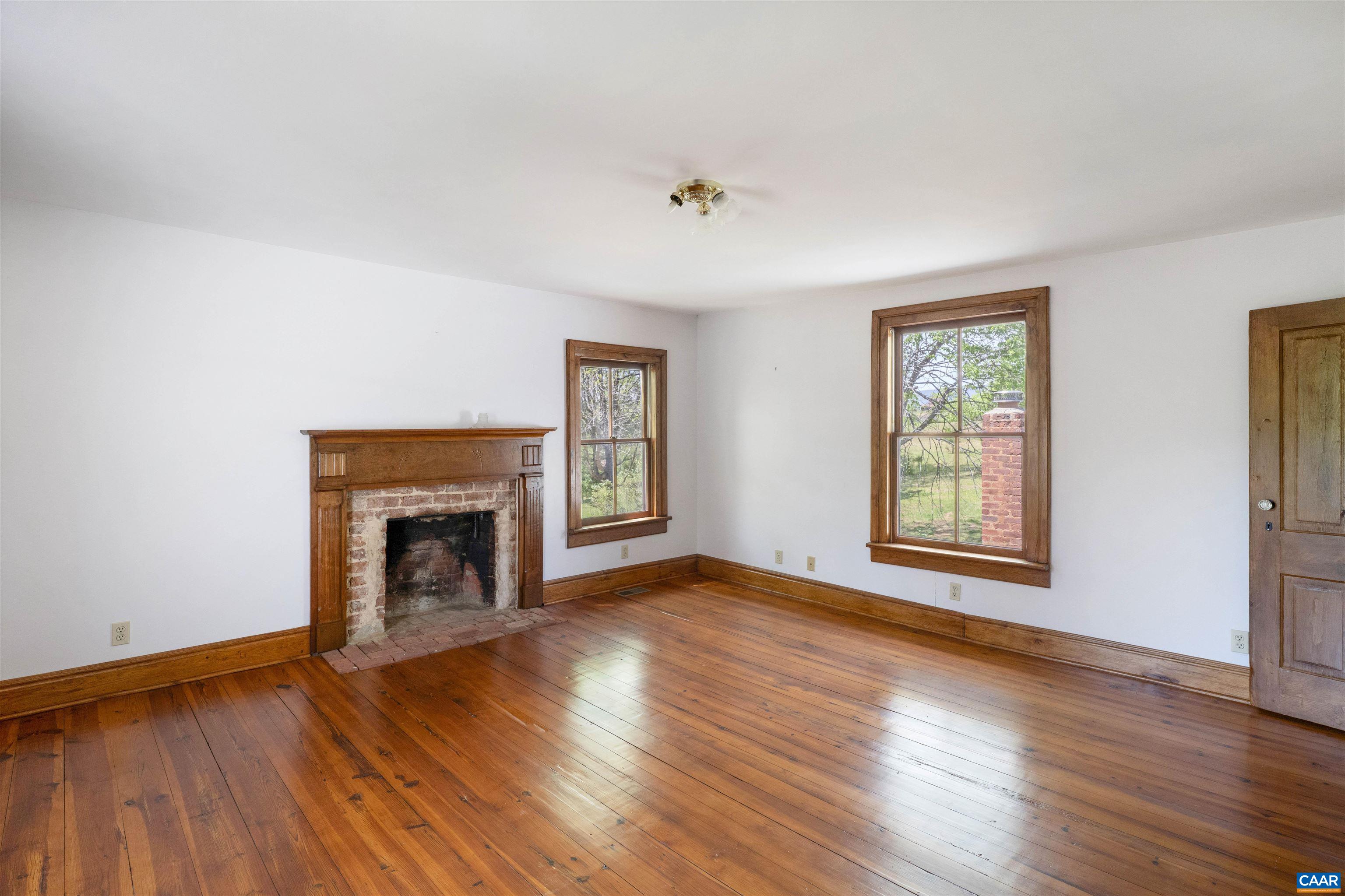 1888 Craigs Store Road Afton, VA 22920 - Photo 27 of 73 an empty room with wooden floor fireplace and windows