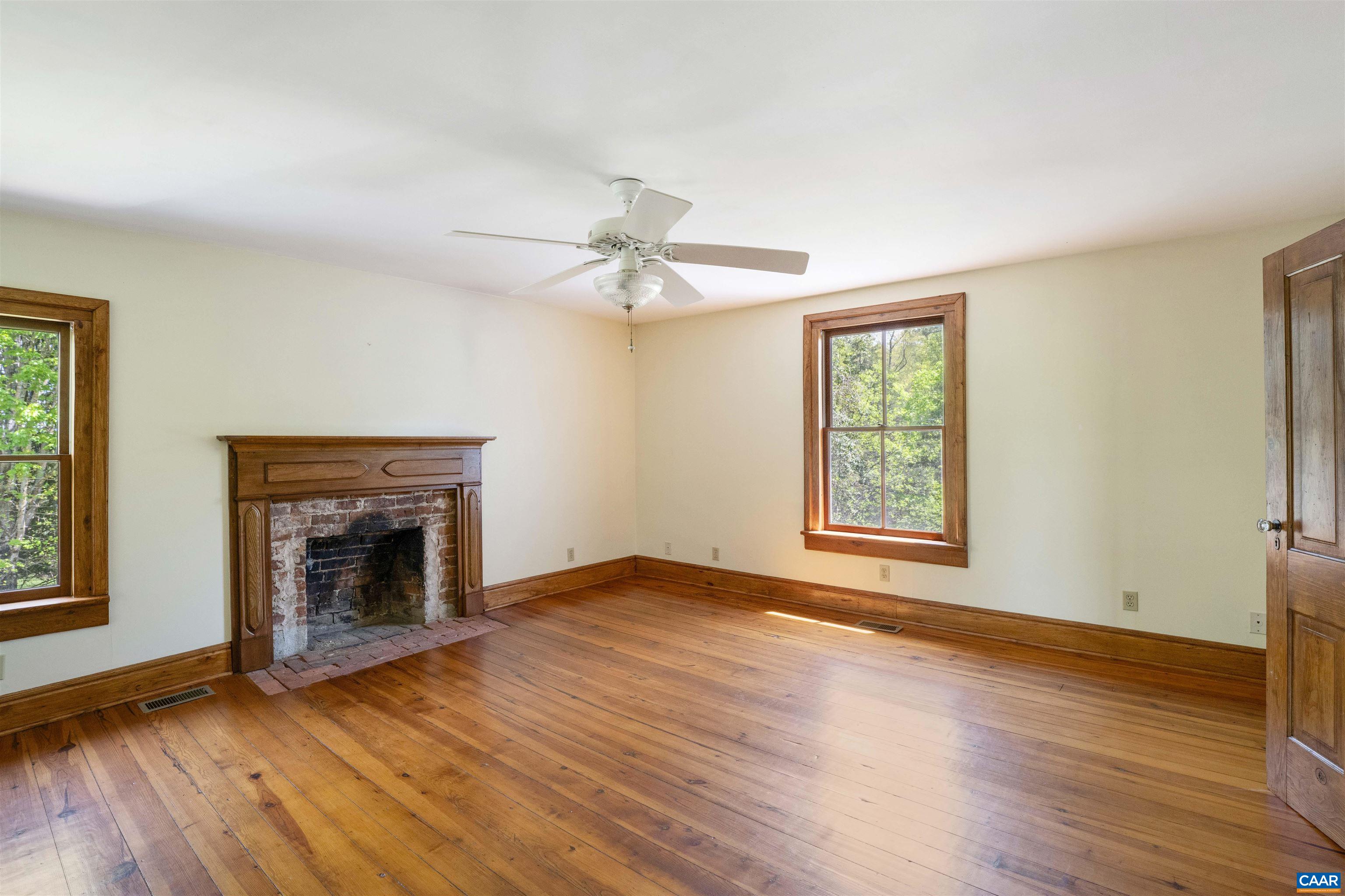 1888 Craigs Store Road Afton, VA 22920 - Photo 32 of 73 an empty room with wooden floor fireplace and windows