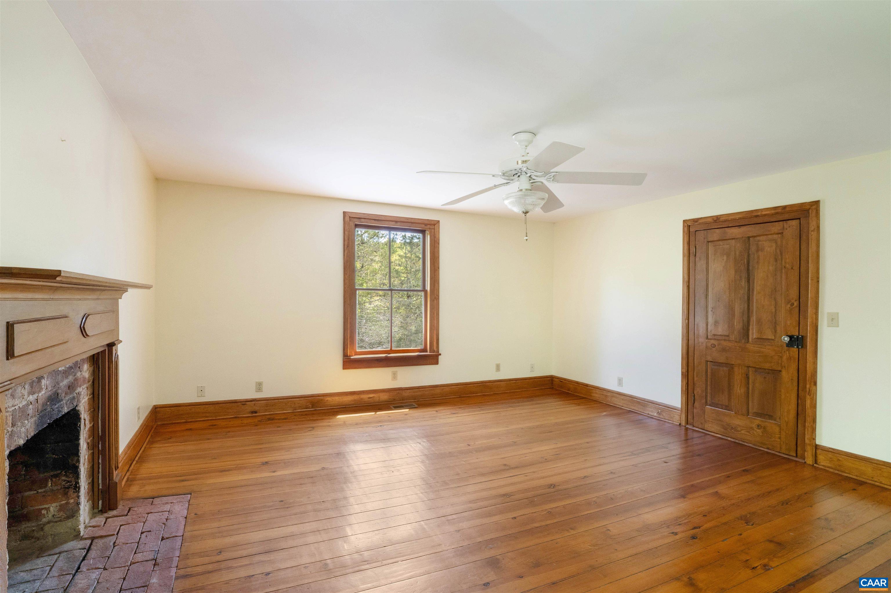 1888 Craigs Store Road Afton, VA 22920 - Photo 35 of 73 an empty room with windows fireplace and wooden floor