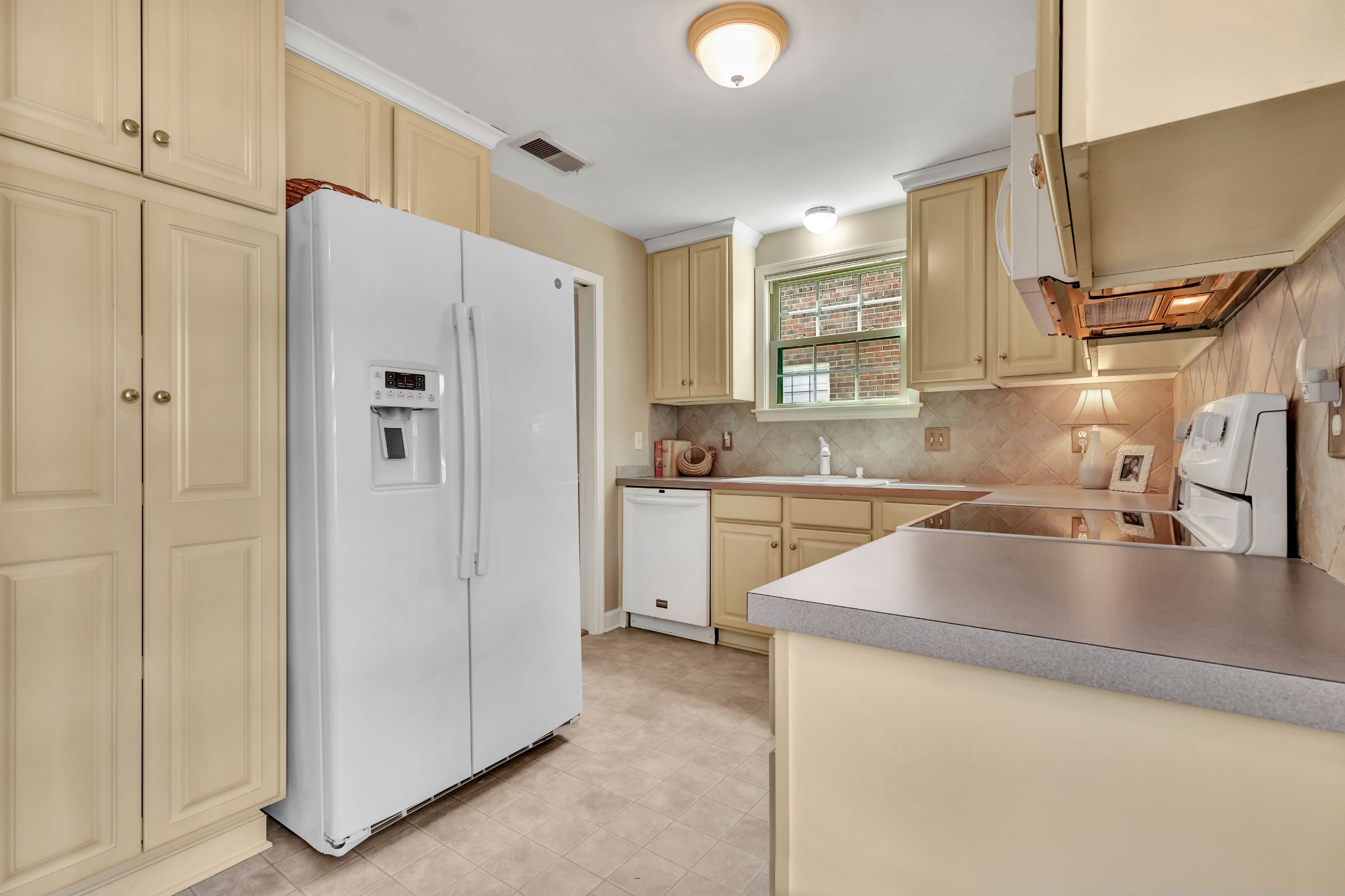 1327 General George Patton Road Nashville, TN 37221 - Photo 7 of 36 a kitchen with a refrigerator sink and cabinets