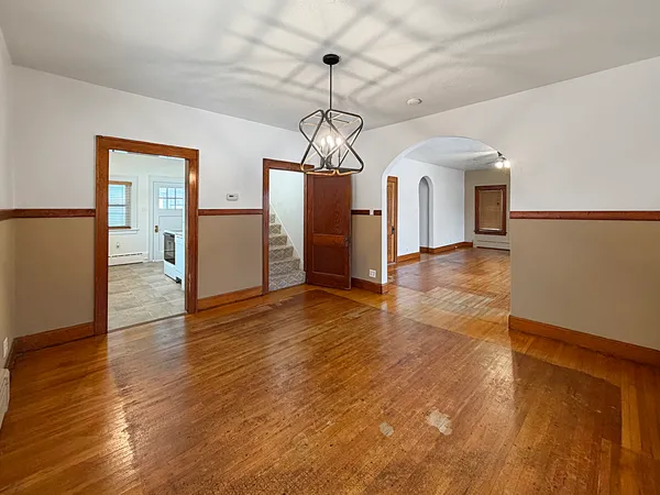 a view of a hallway with wooden floor windows and a chandelier