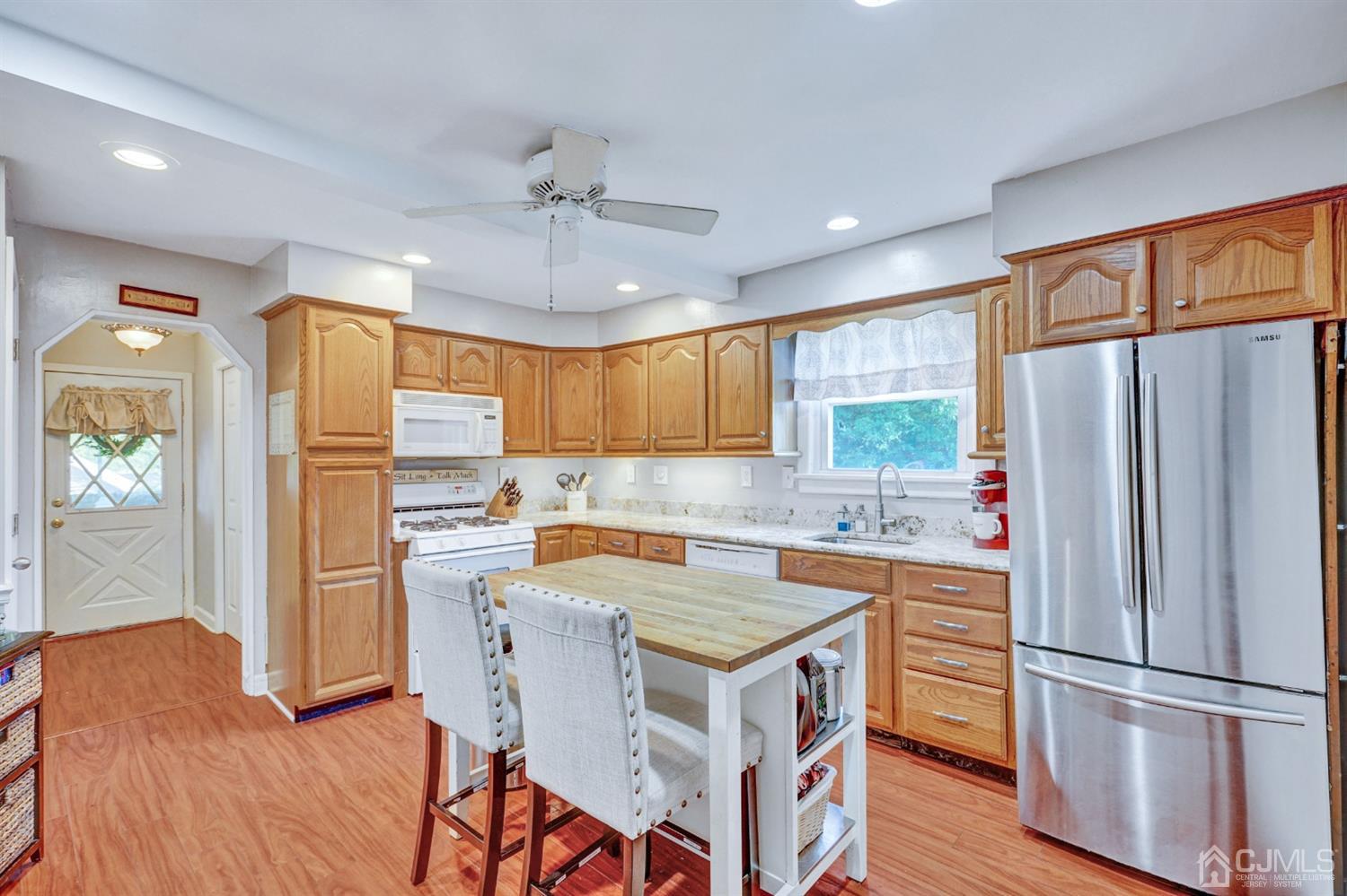 254 Manalapan Road Spotswood, NJ 08884 - Photo 8 of 41 a kitchen with granite countertop a refrigerator a sink a stove a dining table and chairs