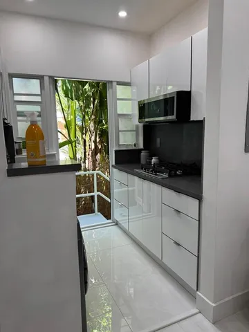 a kitchen with stainless steel appliances kitchen island granite countertop a stove a sink and a microwave