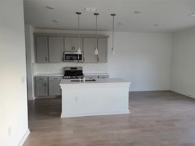 a kitchen with a stove a microwave and cabinets